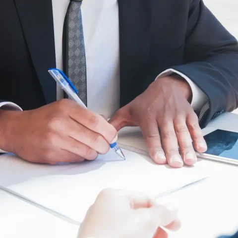 closeup-business-man-writing-paper-sheet-table
