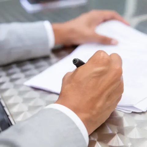 closeup-view-male-hand-signing-paper