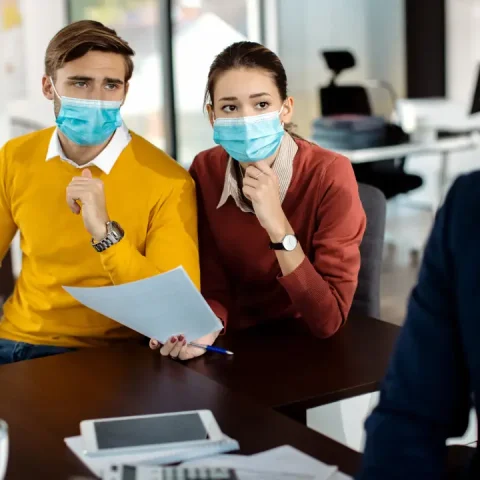 distraught-couple-analyzing-paperwork-while-having-meeting-with-bank-manager-coronavirus-pandemic