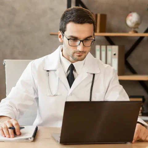 doctor-working-laptop-medium-shot