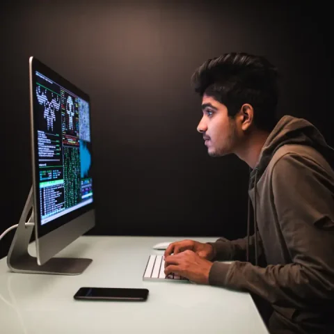 indian-hacker-using-computers-stealing-data-desk-dark