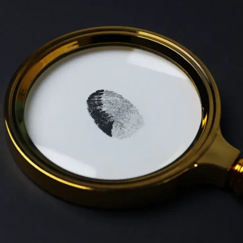 magnifying-glass-with-fingerprints-dark-background