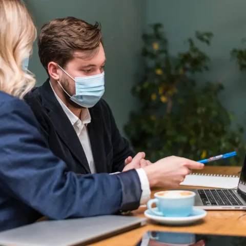 man-woman-talking-about-new-project-while-wearing-medical-masks