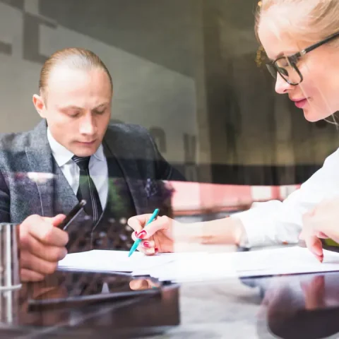 two-businesspeople-examining-document-restaurant