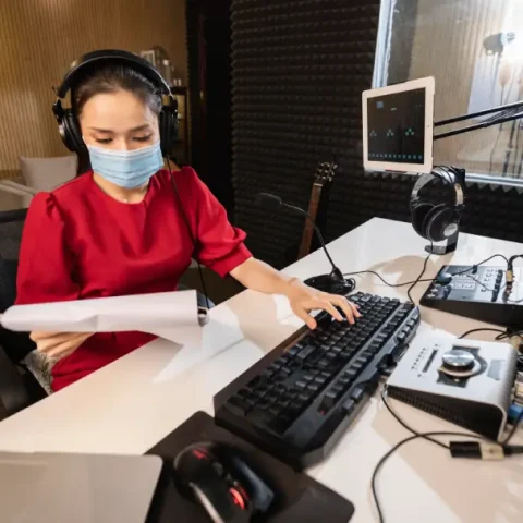 woman-with-face-mask-working-radio-with-professional-equipment