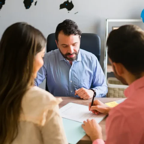 you-got-deal-young-man-signing-sales-contract-holiday-vacation-with-his-wife-sales-representative-closing-deal-timeshare-sale-with-some-customers-travel-agency